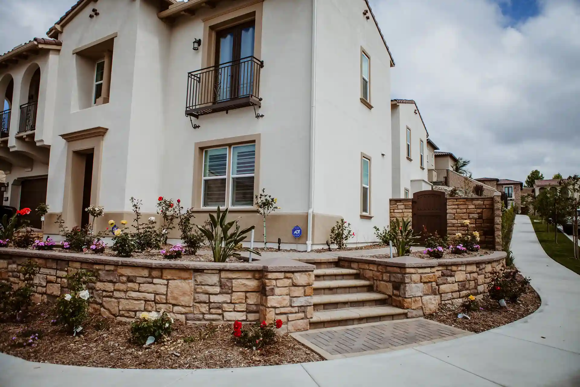 Photo of landscaped home entrance featuring stone retaining walls and decorative steps. 